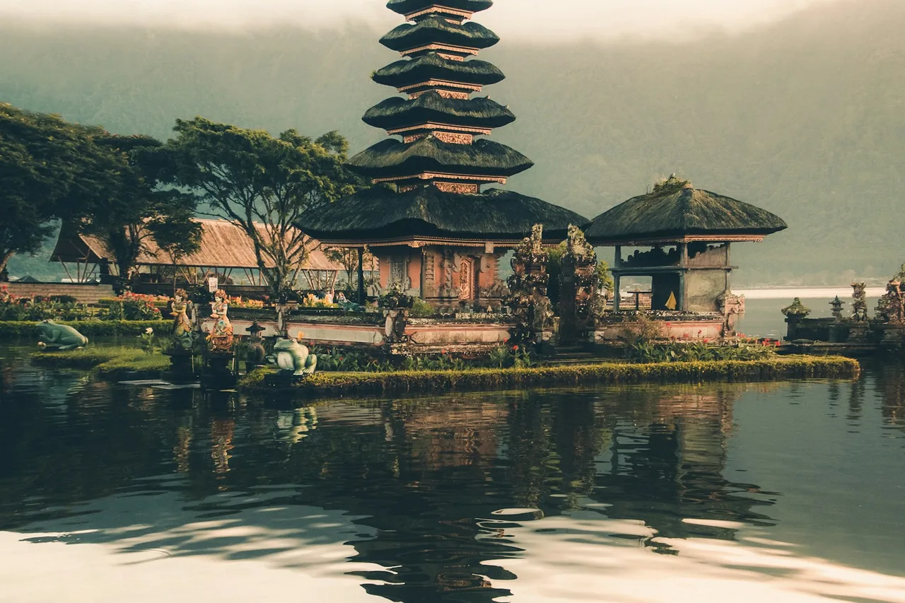 Balinese temple buildings and gardens beside a lake