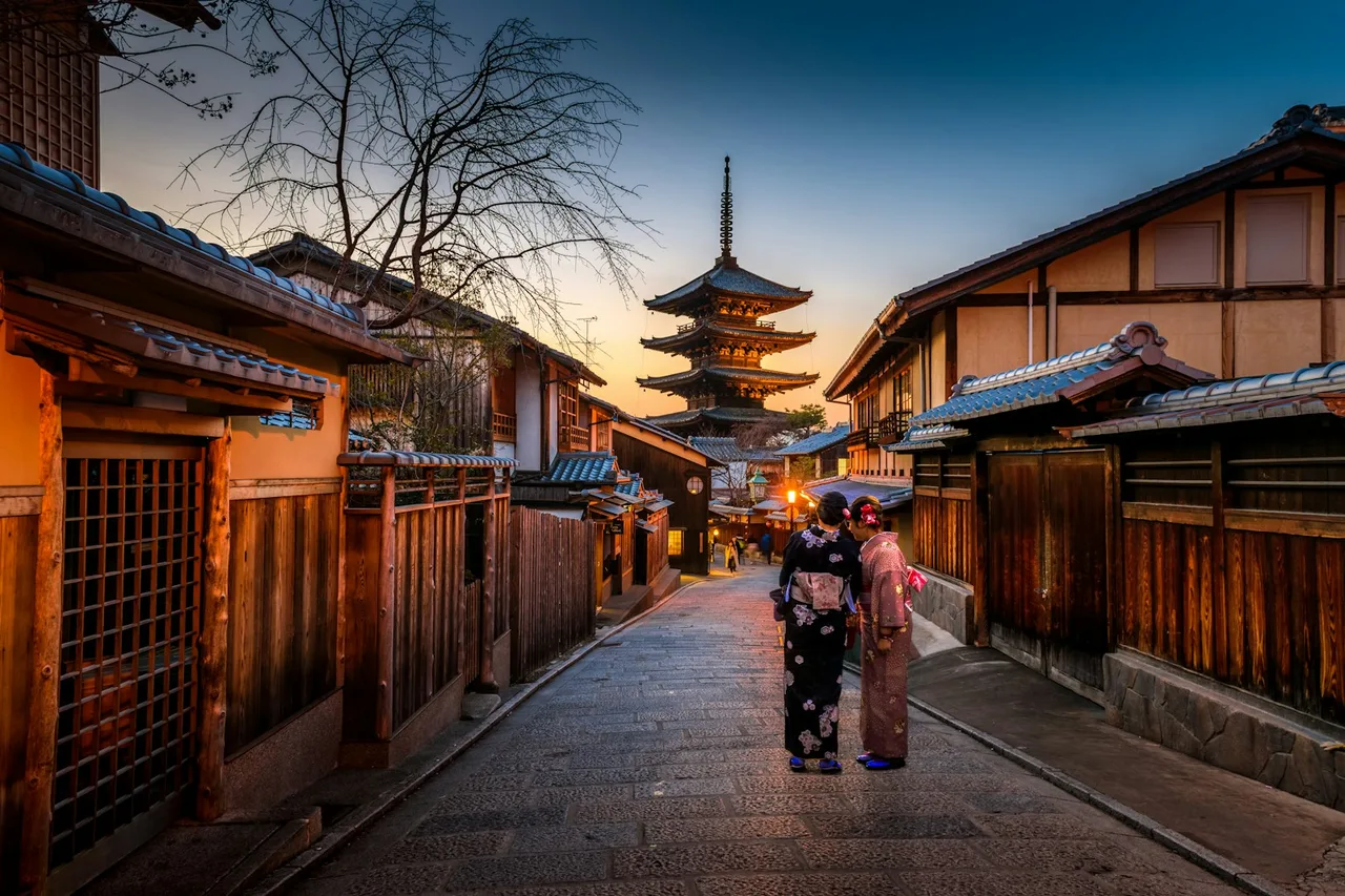 Traditional Japanese street leading toward a pagoda at dusk